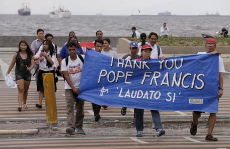 Environmental activists carry a banner as they march towards a Roman Catholic church to coincide with Pope Francis' encyclical on climate change Thursday, June 18, 2015 in Manila, Philippines. In a high-level, 190-page document released Thursday, Francis describes ongoing human damage to nature as "one small sign of the ethical, cultural and spiritual crisis of modernity." The solution, he says, will require self-sacrifice and a "bold cultural revolution" worldwide. (ANSA/AP Photo/Bullit Marquez)