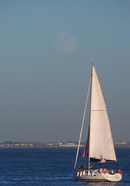 A boat sails up the Tagus river in Lisbon as the moon rises Friday, Aug. 28 2015. When the moon rises Saturday, it will be the first full moon supermoon of the three that will occur in 2015. Supermoon, or perigee moon, is the name given when the full or new moon comes closest to the Earth making it appear bigger. (ANSA/AP Photo/Armando Franca)