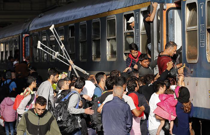 Migrants try to board a train at the railway station in Budapest, Hungary, Thursday, Sept. 3, 2015. Over 150,000 migrants have reached Hungary this year, most coming through the southern border with Serbia, and many apply for asylum but quickly try to leave for richer EU countries.(ANSA/AP Photo/Frank Augstein)