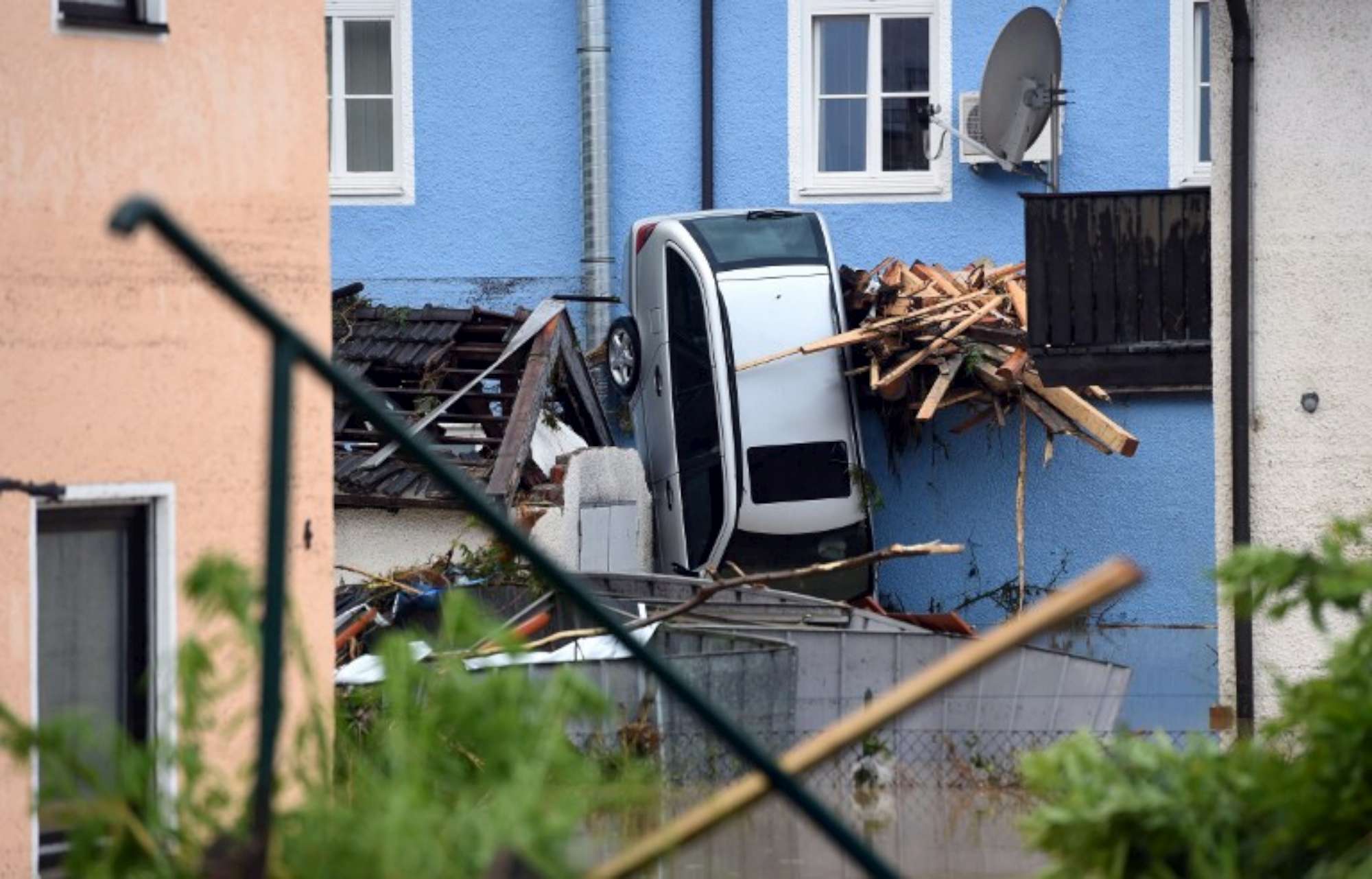 A car that was pressed against a facade by the floods is seen in Simbach am Inn, southern Germany, on June 1, 2016.  Incessant rain in regions of Germany, France and Austria led to flash flooding, forcing residents to seek refuge on rooftops and stranding hundreds of pupils at their school overnight, authorities said. / AFP PHOTO / DPA / Tobias Hase / Germany OUT
